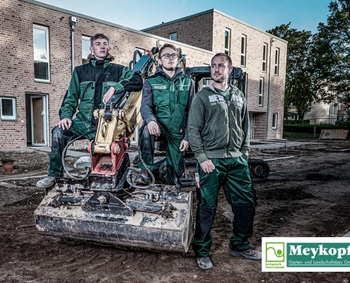 Meykopff-Luebeck-Garten-Landschaftsbau- Team sitzt vor dem Bagger